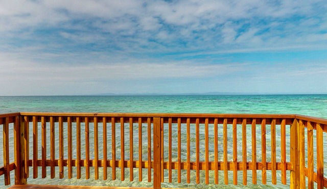 Rustic overwater cabin with oceanfront deck, island kitchen & sea breeze views in Placencia